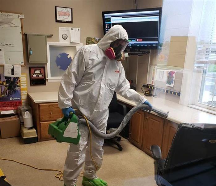 SERVPRO technician in PPE doing a cleaning
