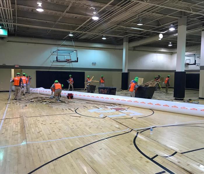 SERVPRO technicians removing the floor of a basketball court in Nashville after water damage