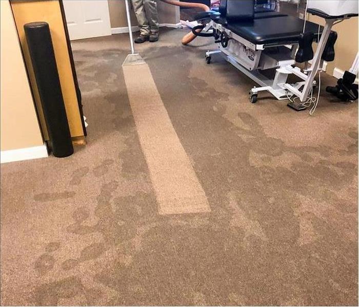 Wet carpet inside a business. Vacuum extracting water from carpet. Concept flood damage in a Nashville, TN business 